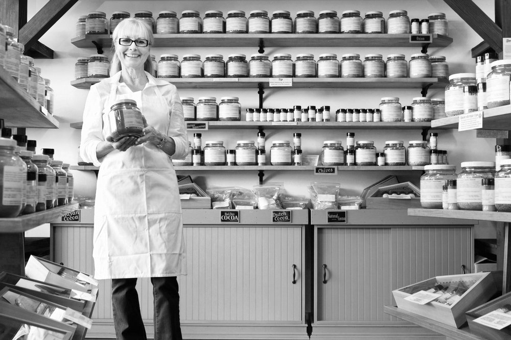 Female business owner standing in her spice shop holding a canister